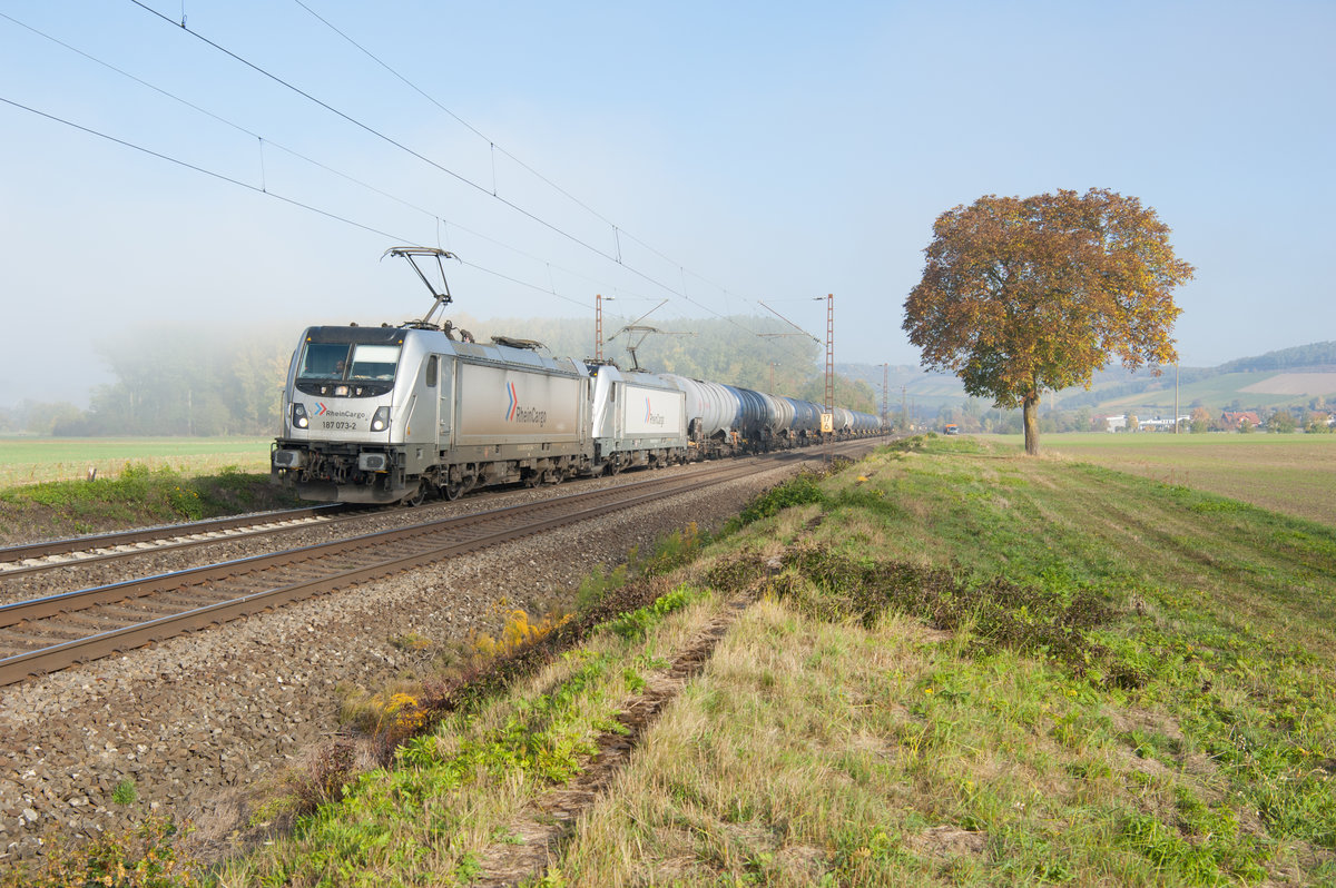 187 073 und eine weitere 187 von Rhein Cargo mit einem Kesselwagenzug bei Retzbach-Zellingen Richtung Würzburg, 13.10.2018
