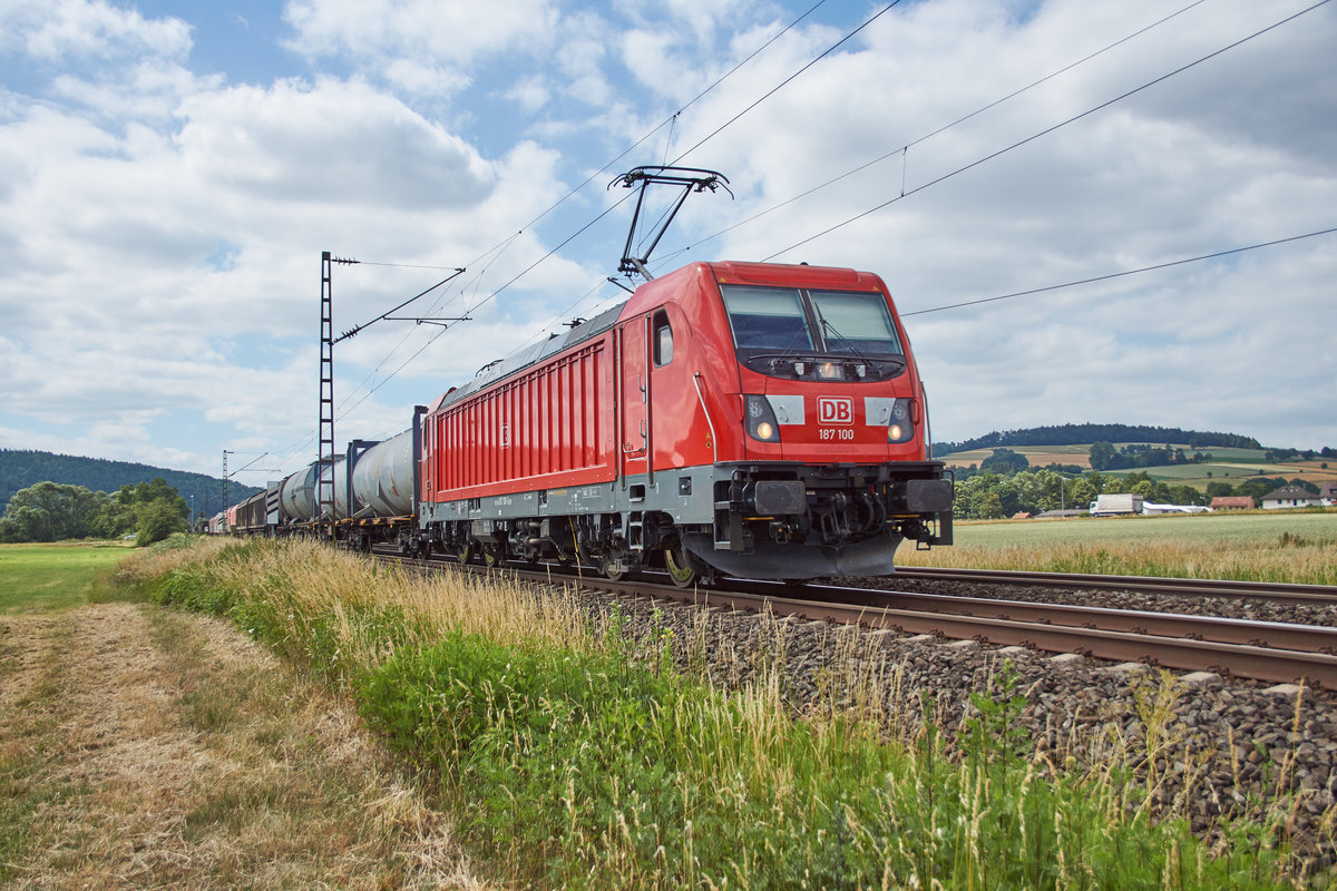 187 100 ist am 20.06.2018 mit einen gemischten Güterzug bei Reilos unterwegs.