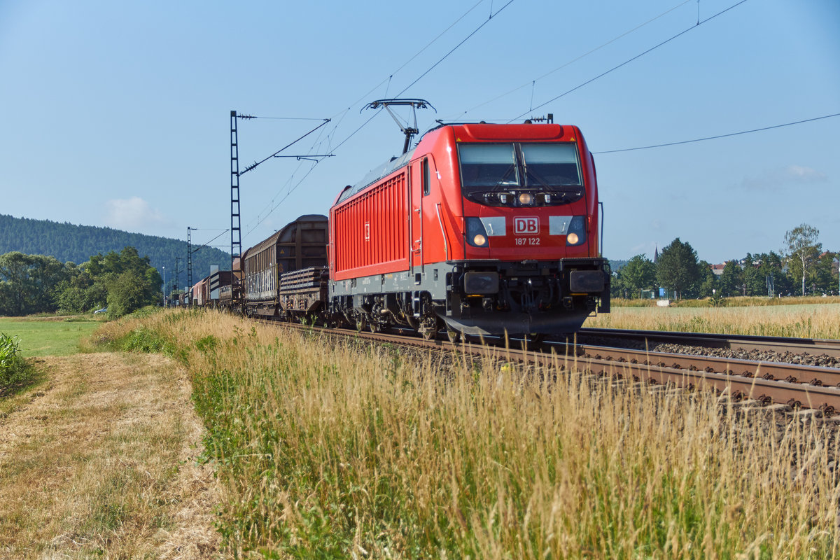 187 122 ist mit seinen gemischten Güterzug in Richtung Bebra unterwegs,gesehen am 20.06.2018 bei Reilos.