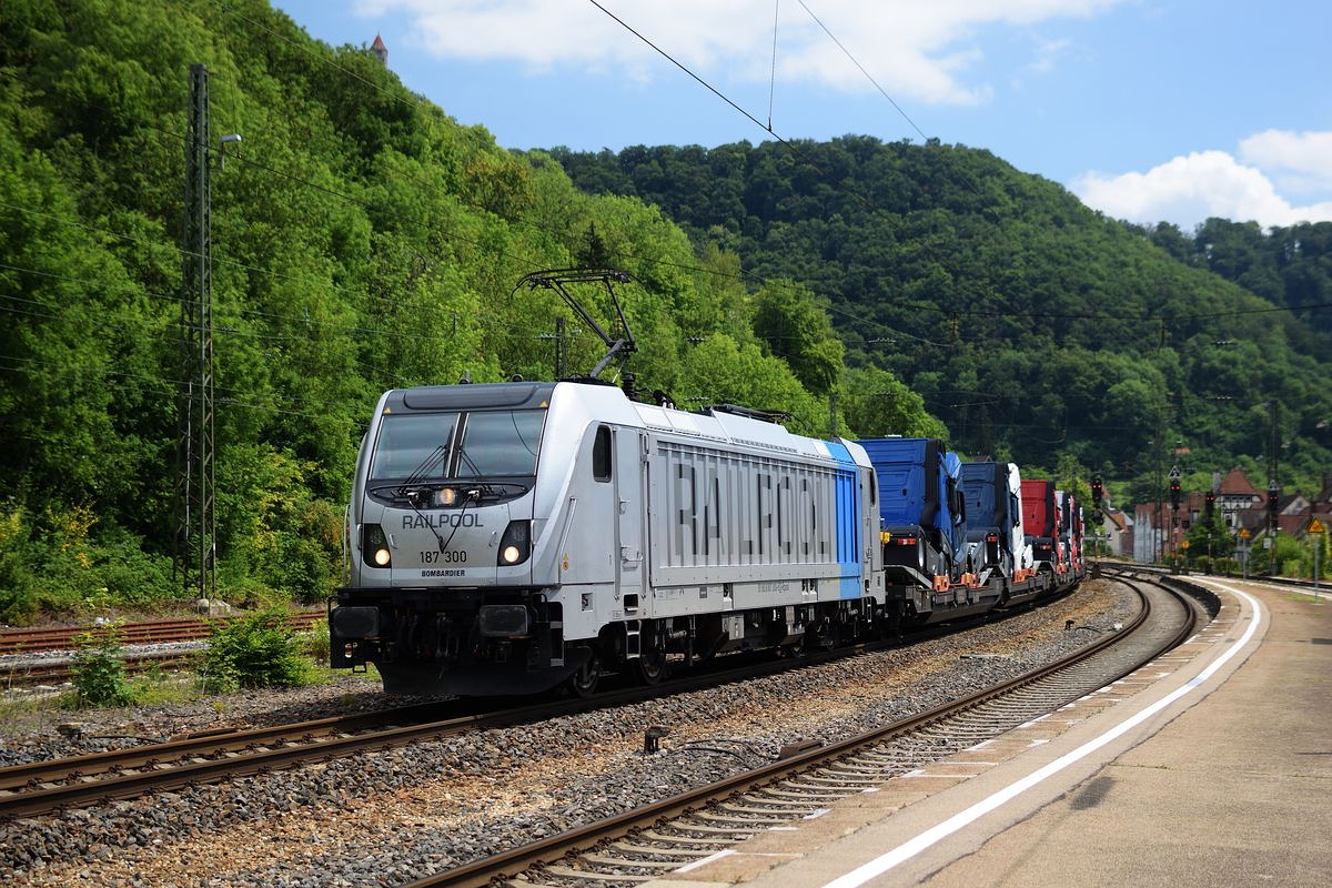 187 300 von Railpool zieht am 12. Juli 2018 einem langen mit LKW beladenen Zug durch Geislingen Richtung Plochingen.