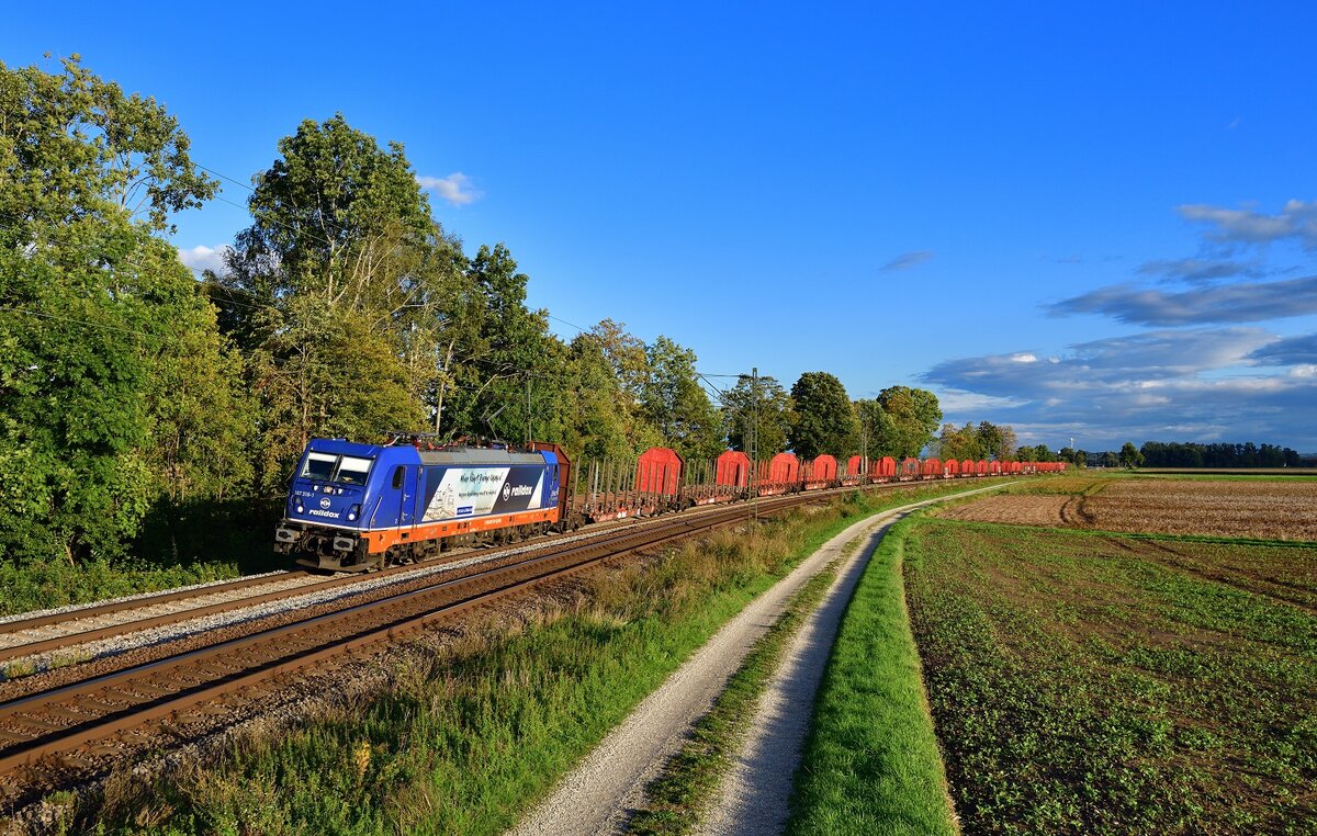 187 318 mit einem Rungenwagenzug am 20.09.2022 bei Langenisarhofen.