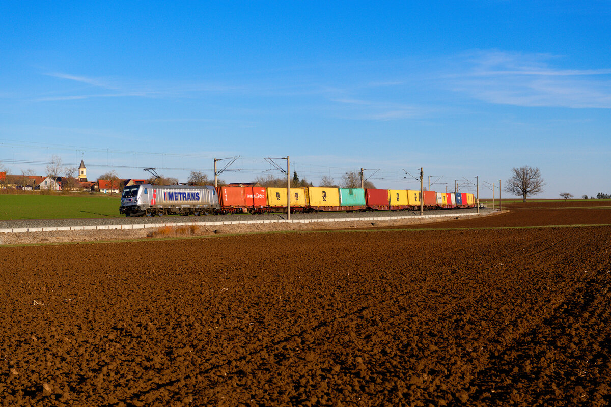 187 511 Akiem/Metrans mit einem Containerzug bei Uffenheim Richtung Würzburg, 06.03.2021