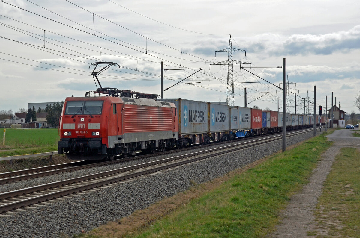 189 061 schleppte am 06.04.22 einen Containerzug durch Braschwitz Richtung Magdeburg. An zweiter Stelle läuft ein blau lackierter CD-Cargo-Tragwagen mit.