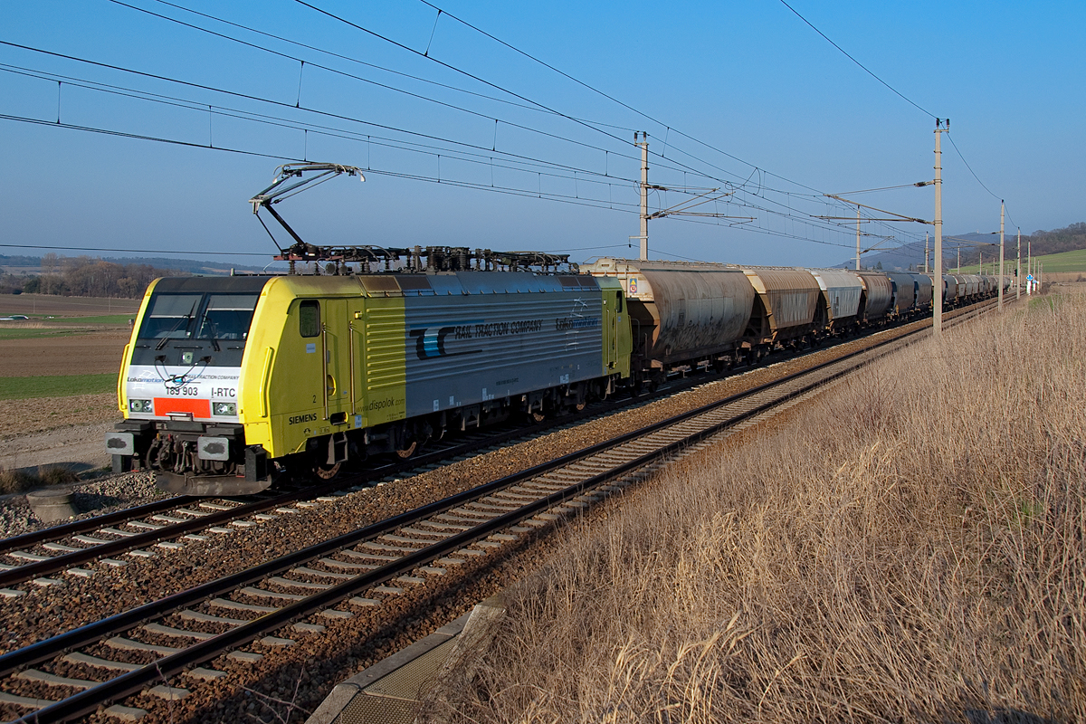 189 903 ist mit einem Getreidezug zwischen Neulengbach und Ollersbach in Richtung Westen unterwegs. Die Aufnahme entstand am 14.03.2014.