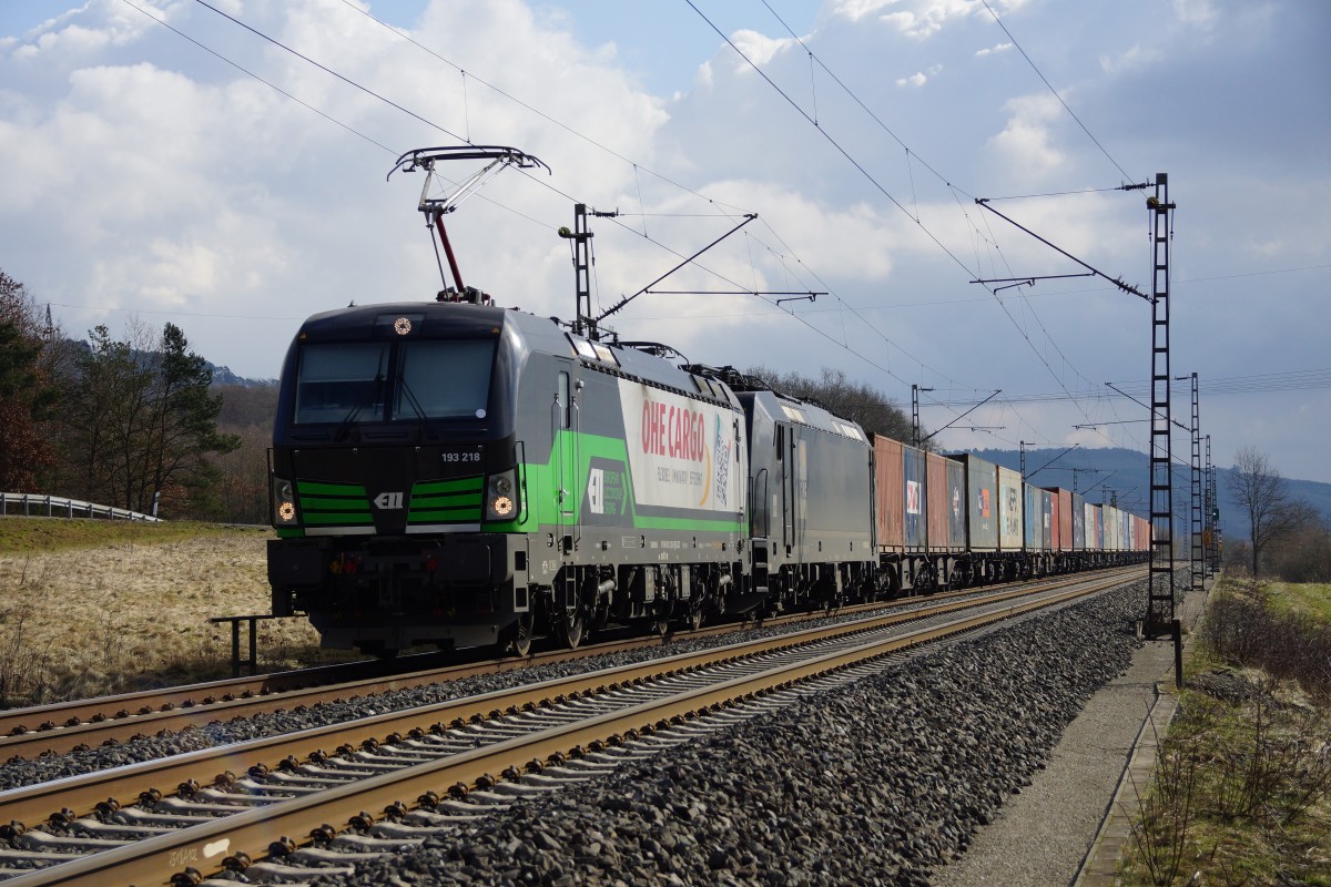 193 218-5(ELL) u. 185 571-7(MRCE) mit einen Containerzug in Richtung Norden bei Harrbach am 25.02.15.