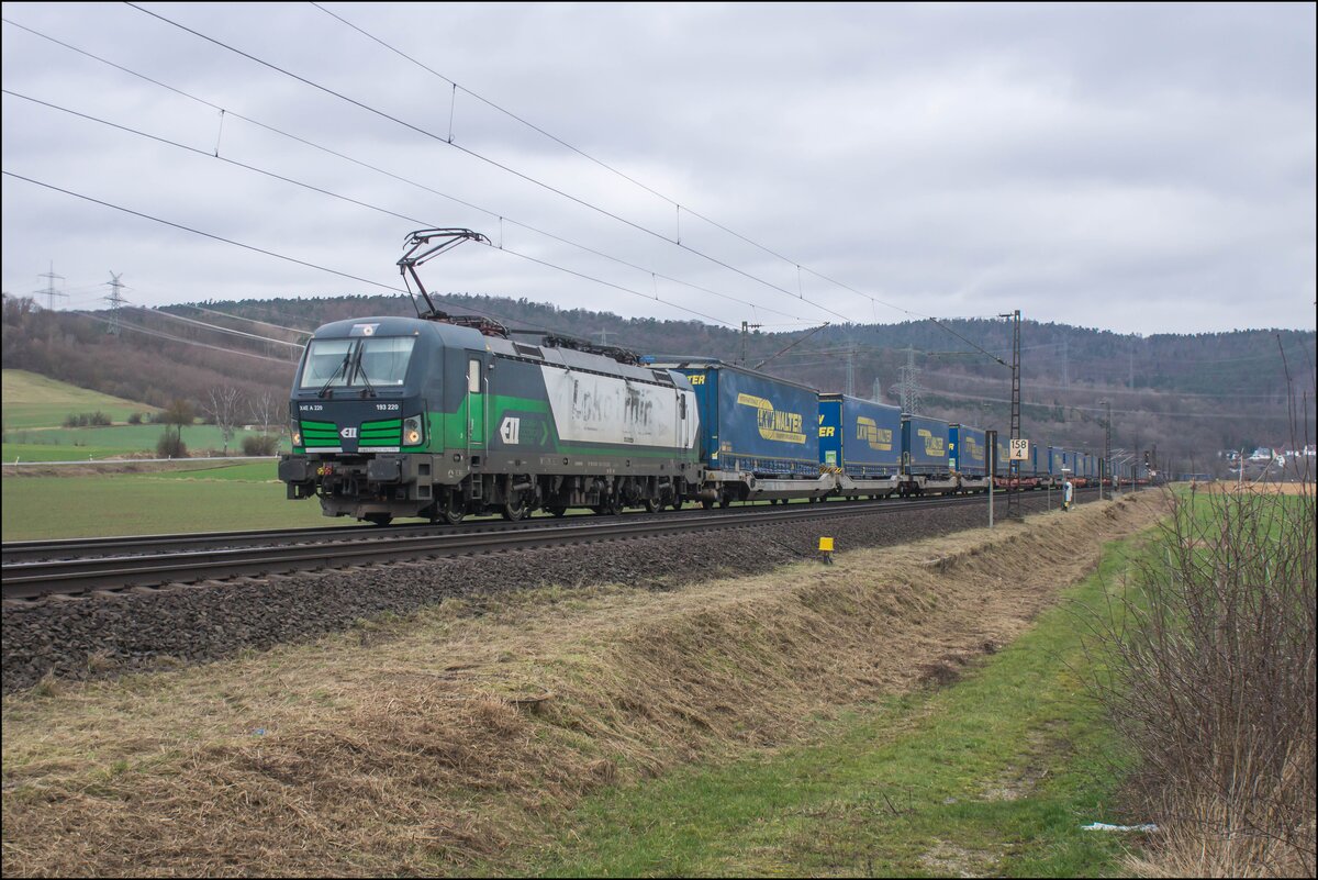 193 220-1 ist am 21.02.2024 mit einem Walterzug bei Reilos in Richtung Süden unterwegs.