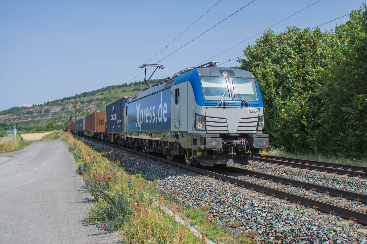 193 537-8 ist mit einem Containerzug in Richtung Süden unterwegs,gesehen in Thüngersheim am 04.07.2023