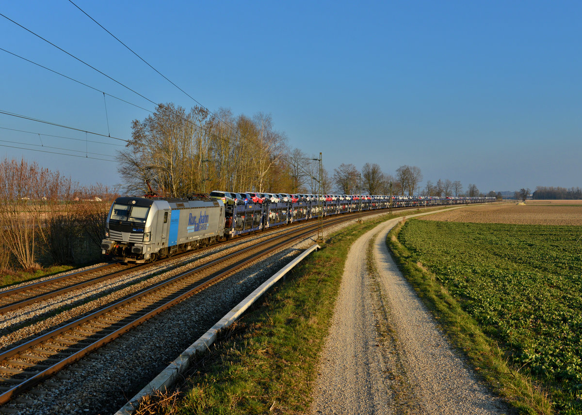 193 810 mit einem Autozug am 20.03.2016 bei Langenisarhofen. 