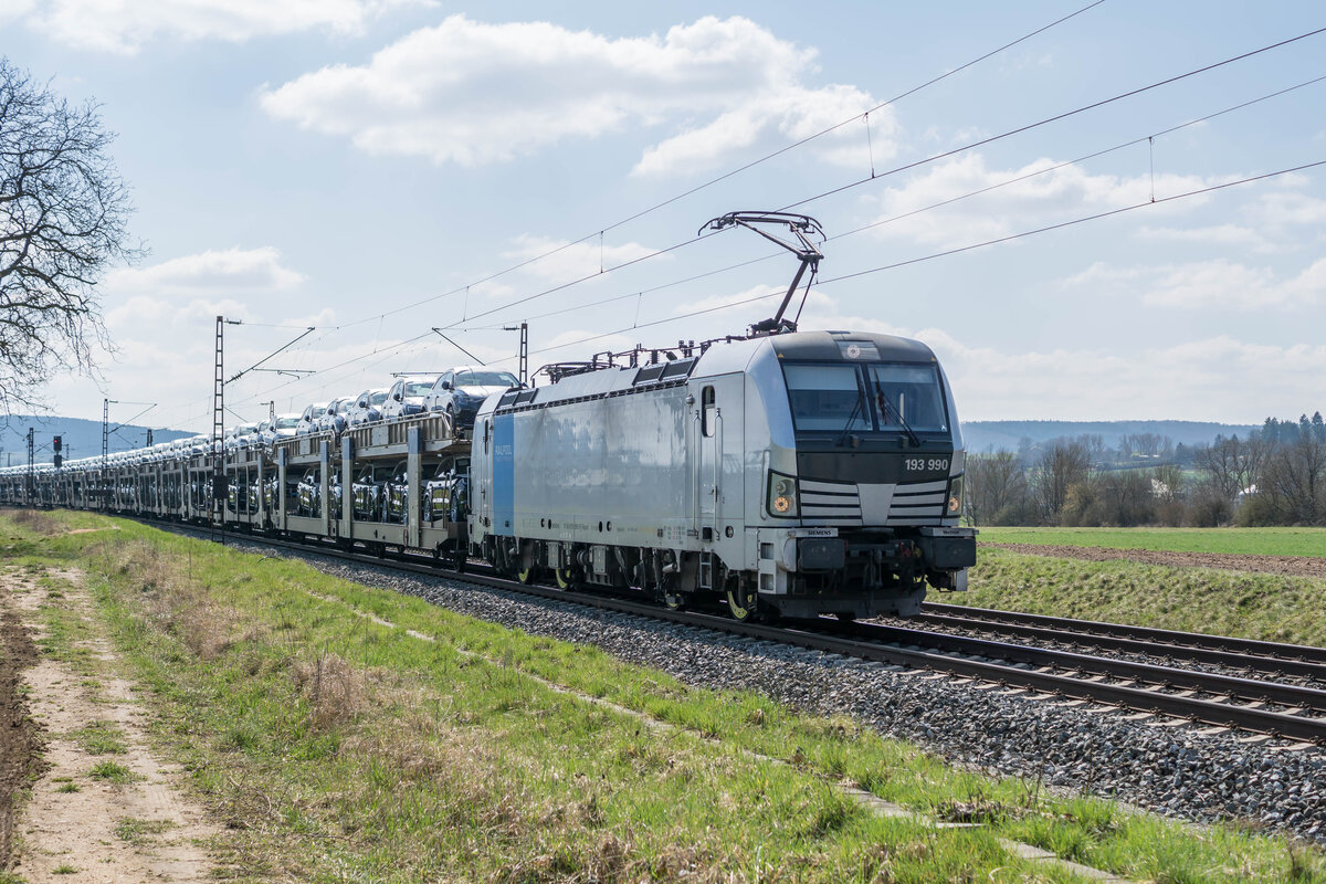 193 990-9 ist mit einem Autozug am 27.03.2025 in Richtung Norden bei Retzbach-Z.unterwegs.