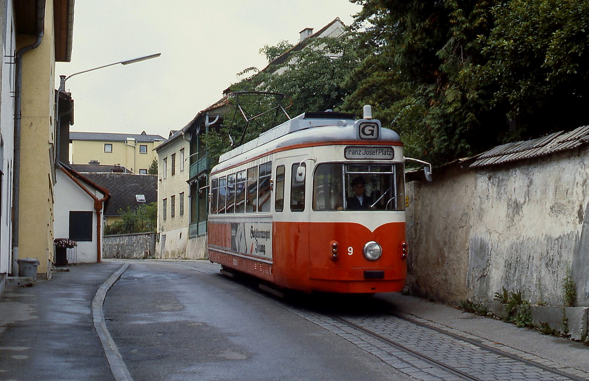 1974 kaufte die Gmundner Straßenbahn drei Triebwagen von der Vestischen Straßenbahn, von denen zwei nach Umbau in den Jahren 1977 und 1983 den Dienst aufnahmen. Im August 1987 fährt GM 9 (ex Vestische Straßenbahn 347) vom Bahnhof durch die enge Kuferzeile hinab ins Zentrum.