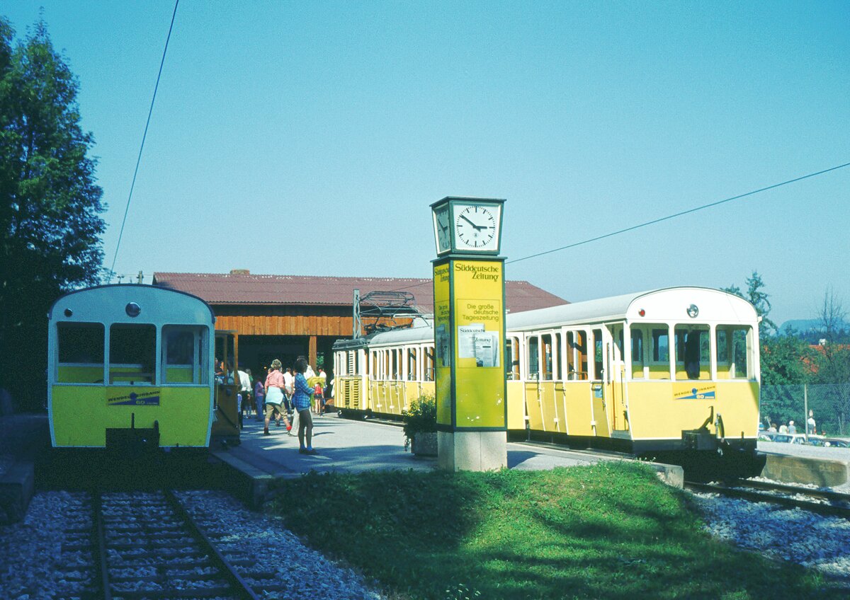 2 Züge im Talbhf._16-08-1973__Der Bau der Wendelstein-Bahn ging auf private Initiative des badischen Industriellen Otto von Steinbeis zurück. 1912 wurde die Bahn in Betrieb genommen. In sensationell schnellen zwei Jahren Bauzeit war die damals noch knapp 10 Kilometer lange Bahnstrecke ab dem Brannenburger Bahnhof fertiggestellt worden. Der damals schon 70-jährige von Steinbeis hatte die Bauleitung selbst übernommen. Sein Vorhaben einer elektrischen Bahn auf den Wendelstein hatte er 1908 bekannt gegeben, vielleicht nicht zufällig ein Jahr nach dem die, auch von Beginn an elektrische, Zahnradbahn Münster – Schlucht(paß) in den Vogesen eröffnet wurde, die damals “höchste Bergbahn im Deutschen Reich“ und auch ca. 10 km lang, beide Bahnen mit dem System Strub. 