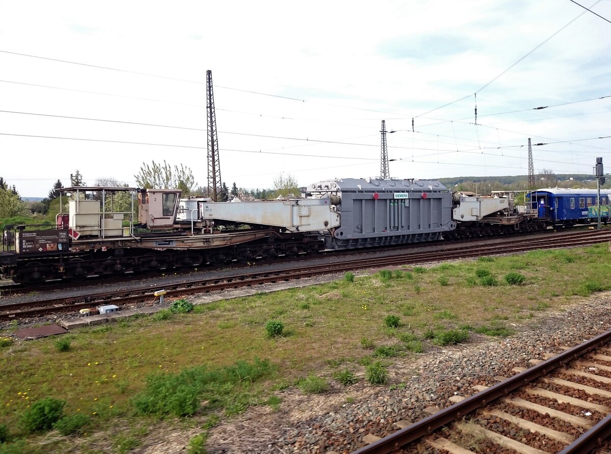 20-achsiger Schwerlasttransportwagen mit Transformator im Bahnhof Naumburg(Saale) am 29.4.2015, aufgenommen aus dem IC 1641 Frankfurt - Leipzig. Damals konnte man in einigen Wagen noch die Fenster öffnen. 👍