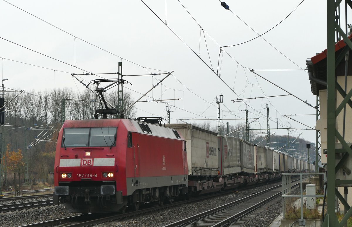 20. November 2018, Lok 152 019 befördert einen Ganzzug mit LKW-Pritschen durch den Bahnhof Hochstadt-Marktzeuln in Richtung Saalfeld.