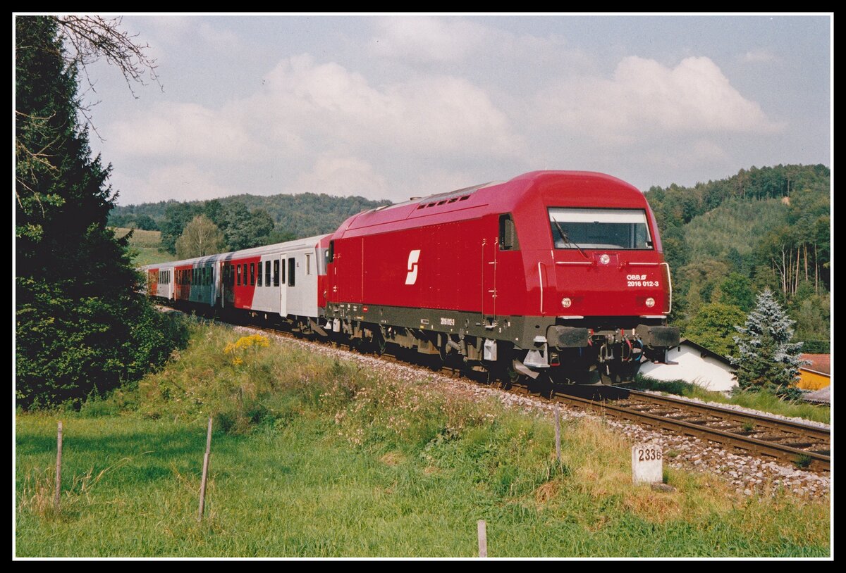 2016 012 fährt am 3.09.2002 mit R4719 bei Laßnitzhöhe Richtung Graz. Die ersten Loks der Baureihe 2016  Herkules  wurden noch mit dem alten ÖBB-Zeichen (Pflatsch) geliefert. Einige hatte das Zeichen an der Seitenwand in Lokmitte angebracht, es gab aber einige Loks wo es außermittig vorhanden war.
