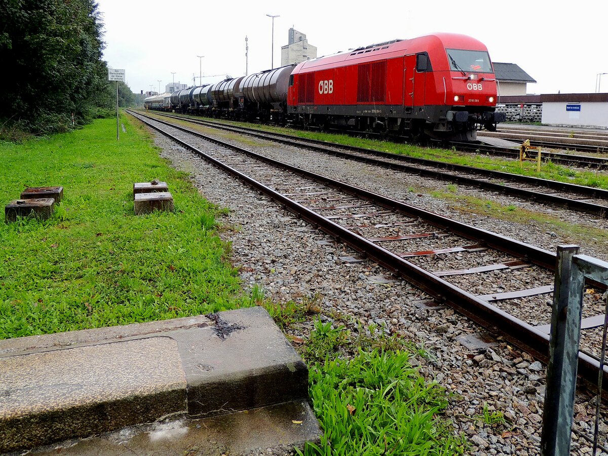 2016 064-5 wartet bei strömenden Regen, sowie im Bereich der Relikte des alten Bahnsteges, geduldig auf die Ausfahrt aus dem Bhf. Ried i.I. ;220919