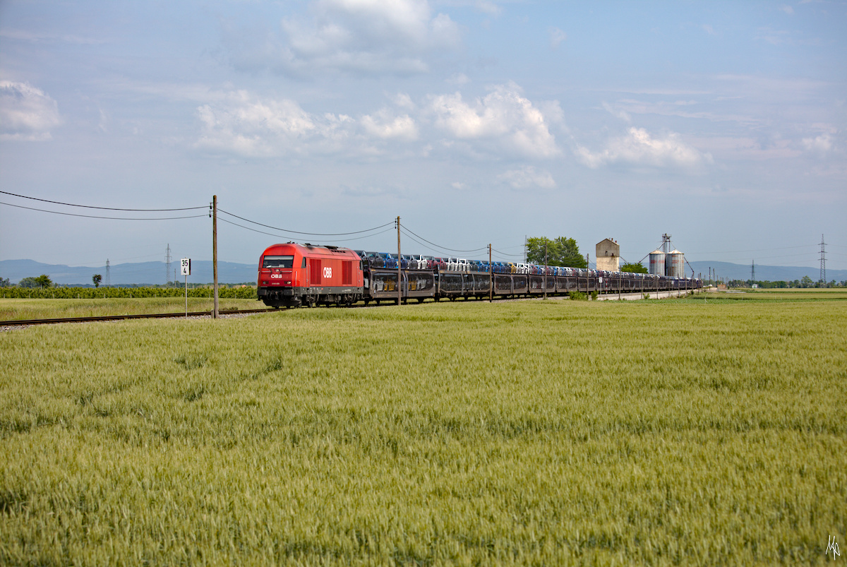 2016.026 mit dem einzigen Güterzug der Strecke, im Hintergrund  das Wahrzeichen der Strecke  - eine Mühle, die auch einmal einen Bahnanschluss hatte. (13.06.2020)