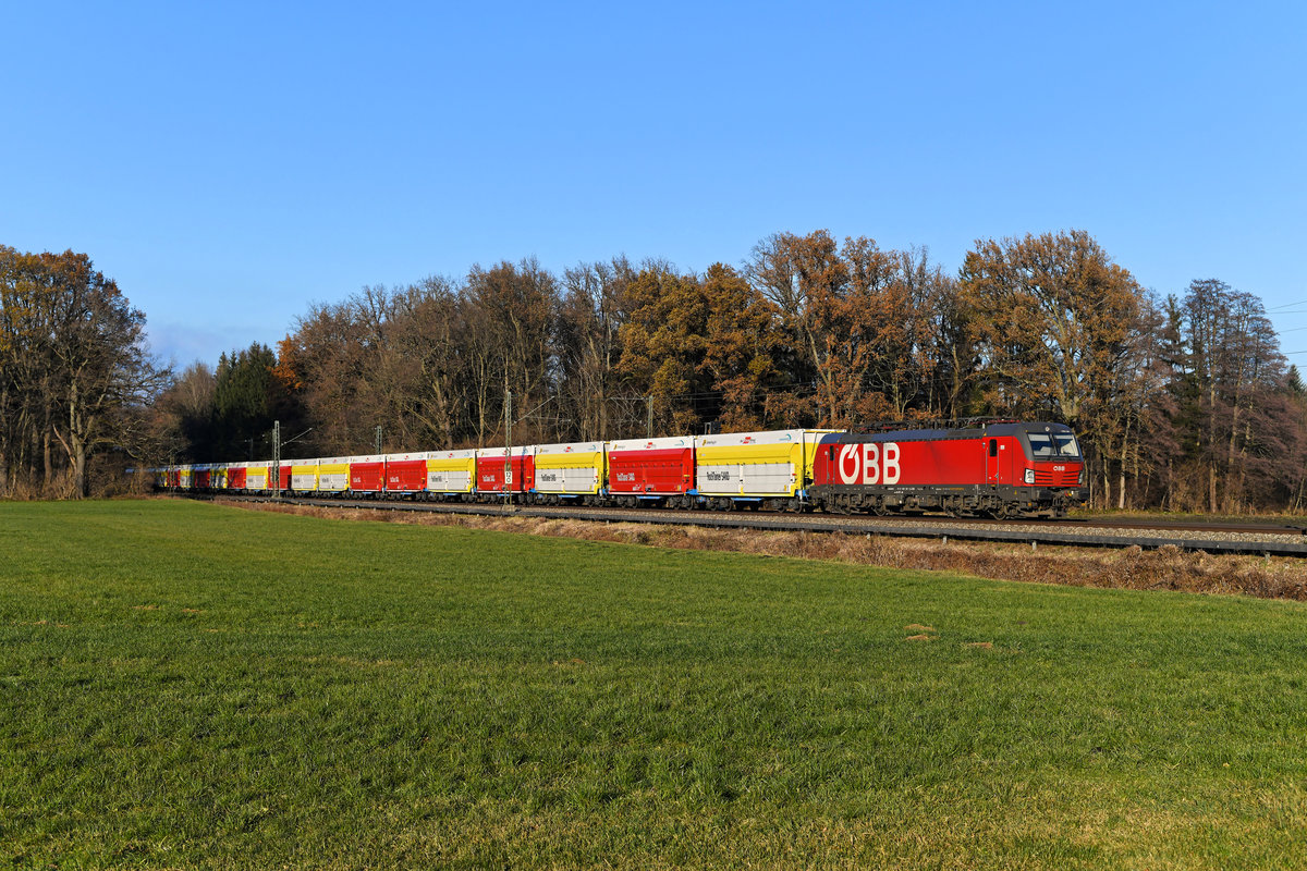 2020 gab es eine Änderung im Verkehr von und zum Zementwerk Rohrdorf. Statt Tauri und den alten Waggons des Typs Fals kommen nun die Loks der Baureihe 1293 und die neuen mit sogenannten Rocktainern beladenen Flachwagen von Innofreight zum Einsatz. Am 25. November 2020 setzte 1293.007 mit ihrer bunten Wagenschlange einen kräftigen Farbakzent im herbstlich eingefärbten Inntal. Entstanden ist die Aufnahme zwischen Reischenhart und Brannenburg.
