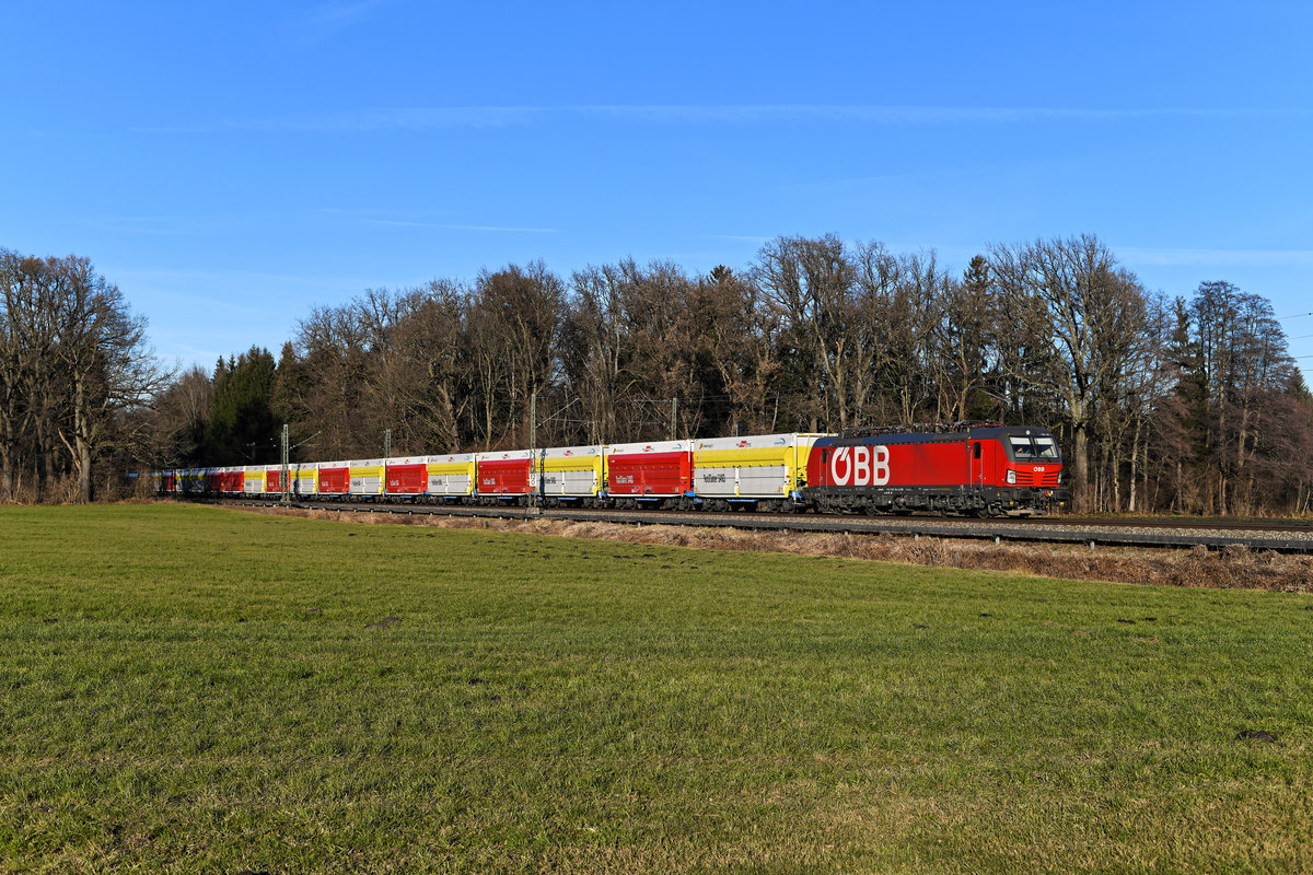 2020 gab es eine Änderung im Verkehr von und zum Zementwerk Rohrdorf. Statt Tauri und den alten Waggons des Typs Fals kommen nun die Loks der Baureihe 1293 und die neuen mit sogenannten Rocktainern beladenen Flachwagen von Innofreight zum Einsatz. Am 18. Dezember 2020 setzte 1293.195 mit ihrer bunten Wagenschlange einen kräftigen Farbakzent im spätherbstlich eingefärbten Inntal. Entstanden ist die Aufnahme zwischen Reischenhart und Brannenburg. Die Leistung hatte ich zwar erst kürzlich fotografiert, der neue und saubere Wagenpark rechtfertigte aber ein weiteres Bild. 