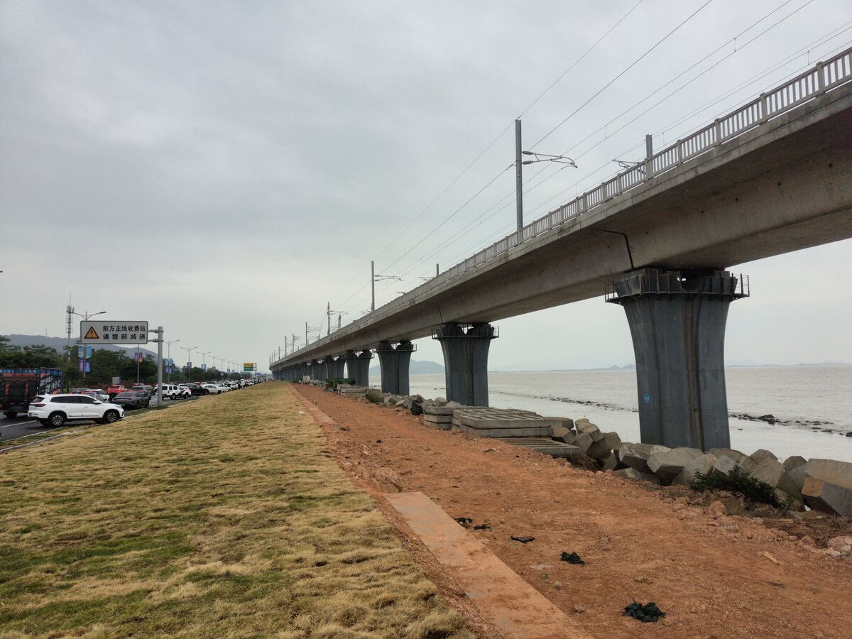 2024.11.10, ZhuHai Airport ICR, north of SanZao East Station next to GuangDong Provincial Highway S272 (ZhaoQing Railway Station to ZhuHai Airport). ZhuHai ICR connect the city center to the Airport which, as lack of competitiveness compare to GuangZhou/ShenZhen/Hong Kong, focused on holding international aviation exhibition. Just north of here was the impressive 1.9km JinWan Bridge where the ZhuHai ICR got squeeze in middle between the highway.
///
2024.11.10, ZhuHai Airport ICR, nördlich des Bahnhofs SanZao East neben der GuangDong Provincial Highway S272 (ZhaoQing Railway Station to ZhuHai Airport). Das ZhuHai ICR verbindet das Stadtzentrum mit dem Flughafen, der aufgrund seiner mangelnden Wettbewerbsfähigkeit im Vergleich zu GuangZhou/ShenZhen/Hongkong auf die Durchführung internationaler Luftfahrtausstellungen ausgerichtet ist. Nördlich von hier befand sich die beeindruckende, 1,9 km lange JinWan-Brücke, auf der die ZhuHai ICR in der Mitte zwischen die Autobahn gequetscht wurde.