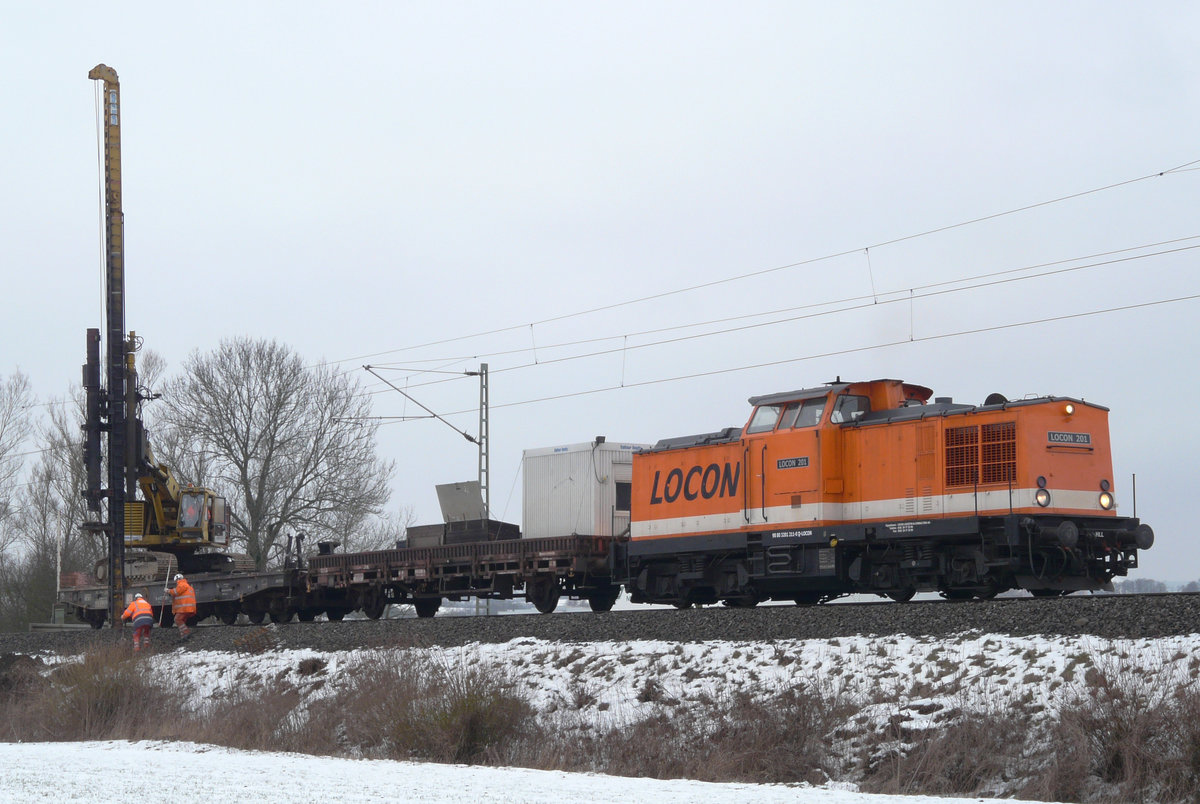 21. Januar 2010: Auf der Frankenwaldstrecke  zwischen Hochstadt und Küps werden neue Masten für die Fahrleitung gesetzt. Im Bahnhof Hochstadt hat der Bautrupp seine Basis. Heute ist Lok 201 mit der auf einem Flachwagen platzierten Ramme zwischen Redwitz und Küps unterwegs. Geschichte der Lok (Auszug aus  V100-online ): 1970 Auslieferung an DR (Bw Reichenbach) als 110 211. 01.01.1992 Umzeichnung in 201 211. 31.05.1995: Ausmusterung im Bh Zwickau (Sachs),  
2004 an LOCON LOGISTIK & CONSULTING AKTIENGESELLSCHAFT, Nr.201.