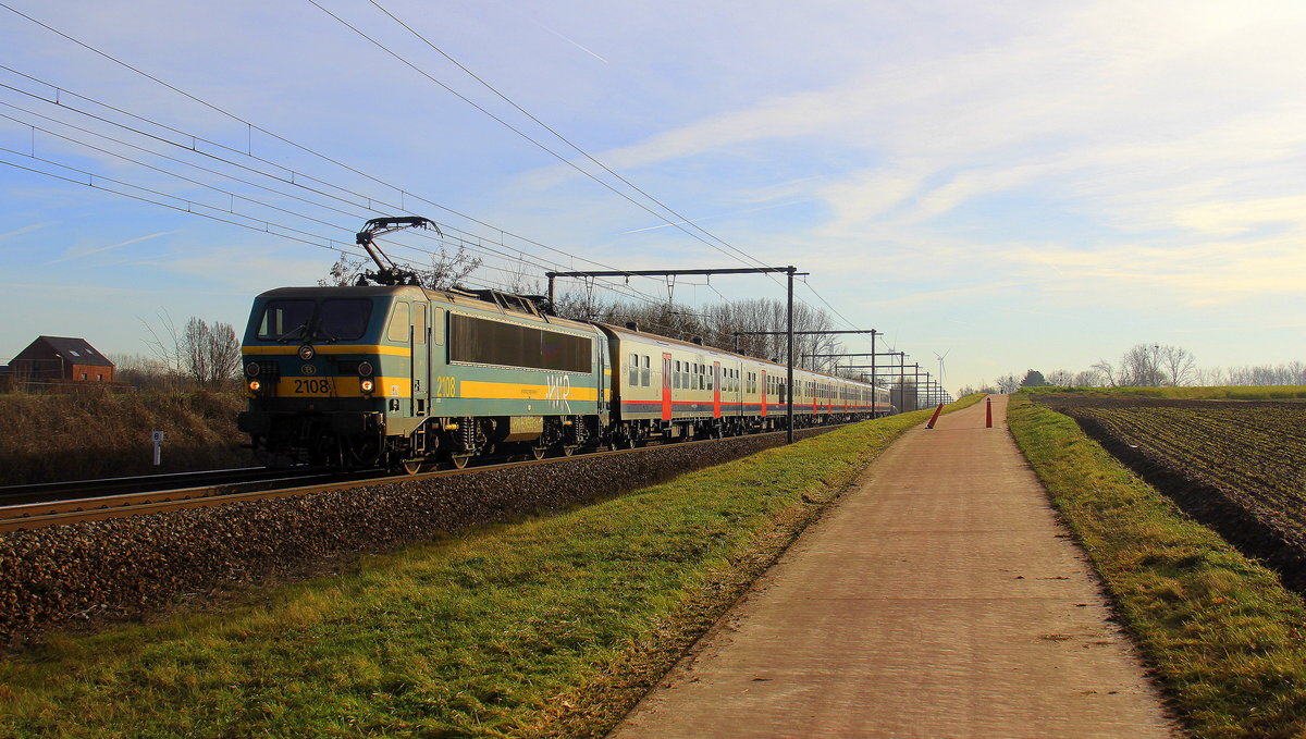 2108 von SNCB kommt mit einem belgischen Personenzug aus Tongeren(B) nach Hasselt(B) und kommt aus Richtung Tongeren(B) und fährt durch Hoeselt(B) in Richtung Hasselt(B).
Aufgenommen von einem Fußgängerweg in Hoeselt(B). 
Bei schönem Winterwetter am kalten Mittag vom 26.12.2018.