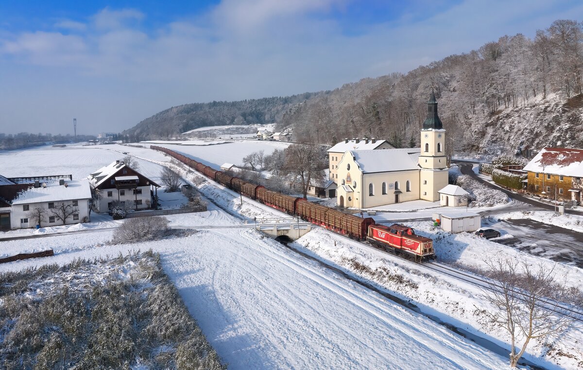 211 024 mit einem Holzzug am 17.12.2022 bei Halbmeile.