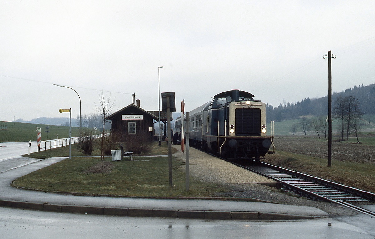 211 322-3 hält Anfang April 1988 mit einem Nahverkehrszug im Haltepunkt Reichertshofen (Strecke Gessertshausen - Markt Wald)