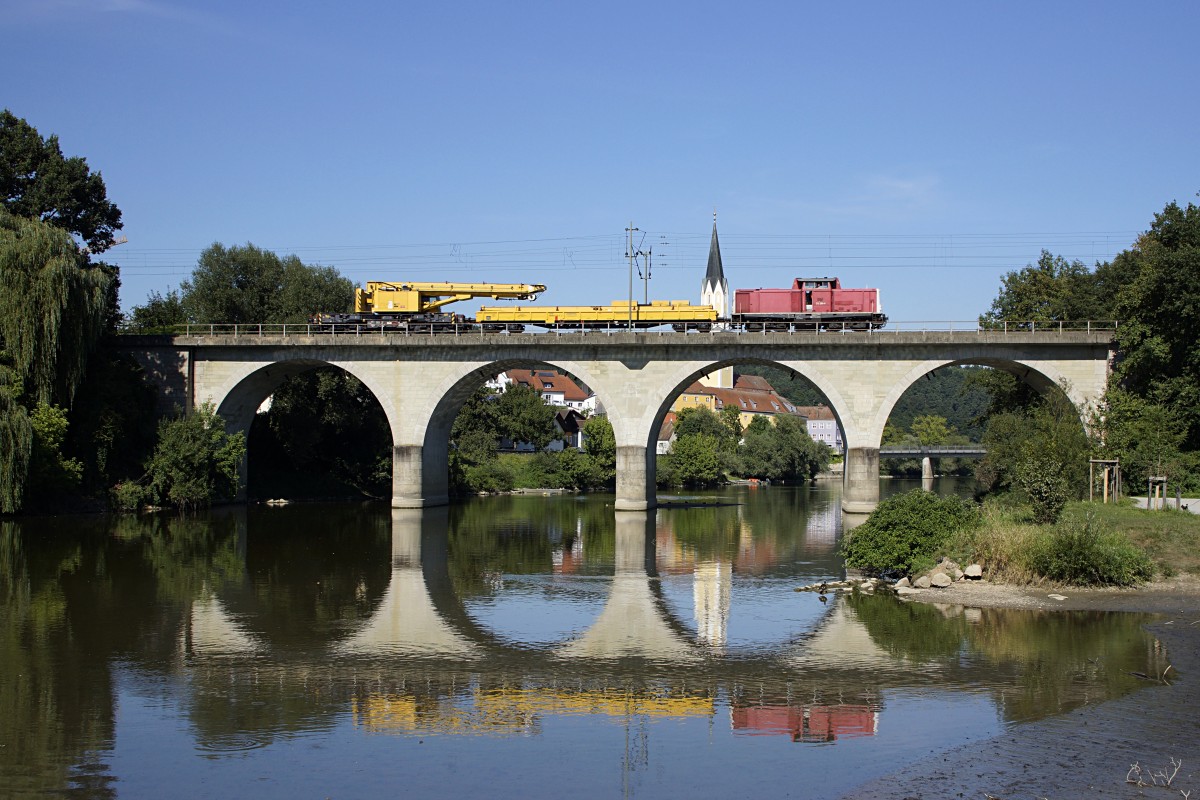 212 284-4 der Bayernbahn GmbH bringt einen Gleisbau-Kran zur Gleisbaustelle im Bahnhof Vilshofen. Aufgenommen auf der Vilsbrücke am 16.08.2013.

Hersteller: MaK
Fabriknummer: 1000331
Indienststellung: 22.09.1965
Erst-Bw: Hagen-Eckesey
ursprüngl. Fahrzeugnr.: V 100 284
Umzeichnungen: 01.01.1968 (212 284-4), 05.09.2008 (92 80 1212 284-4 D-BYB)
Fahrzeugnr. z.Z.d. Aufnahme: 92 80 1212 284-4 D-BYB
Betreibernr. z.Z.d. Aufnahme: 212 284-4
Radsatzfolge: B'B'
Vmax (km/h): 100
Leistung (kW): 990
Kraftübertragung: hydraulich
Dienstmasse (t): 63
Radsatzfahrmasse max. (t): 16
LüP (mm): 12.300