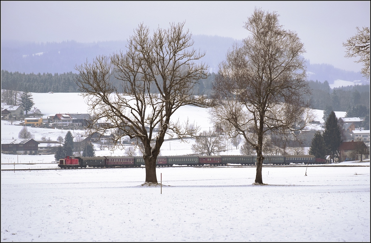 212 284-4 mit einem eigentlich viel zu langen Schnellzug bei Flecken im Allgäu. Statt den Zug nachzuschieben musste sie bedauerlicherweise selbst arbeiten. Trotzdem mit dem abwechslungsreichen Wagenpark ein spannender Anblick. Nach der Lok ein genieteter Schnellzugwagen, ein geschweißter Speisewagen, ein mir unbekannter m-Wagen mit 1/4-Bar, ein Bm, ein Mitropa-Wagen, ein Mitteleinstiegseilzugwagen, ein Bm und ein Am, sowie ein mir unbekannter Schlusswagen im Krokodilsschnauzendesign. Februar 2018.