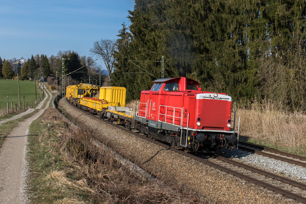 212 298 beschleunigt mit einem Bauzug nach einem kurzen Halt in Richtung Traunstein. Aufgenommen am 28. März 2016 bei Grabenstätt. 