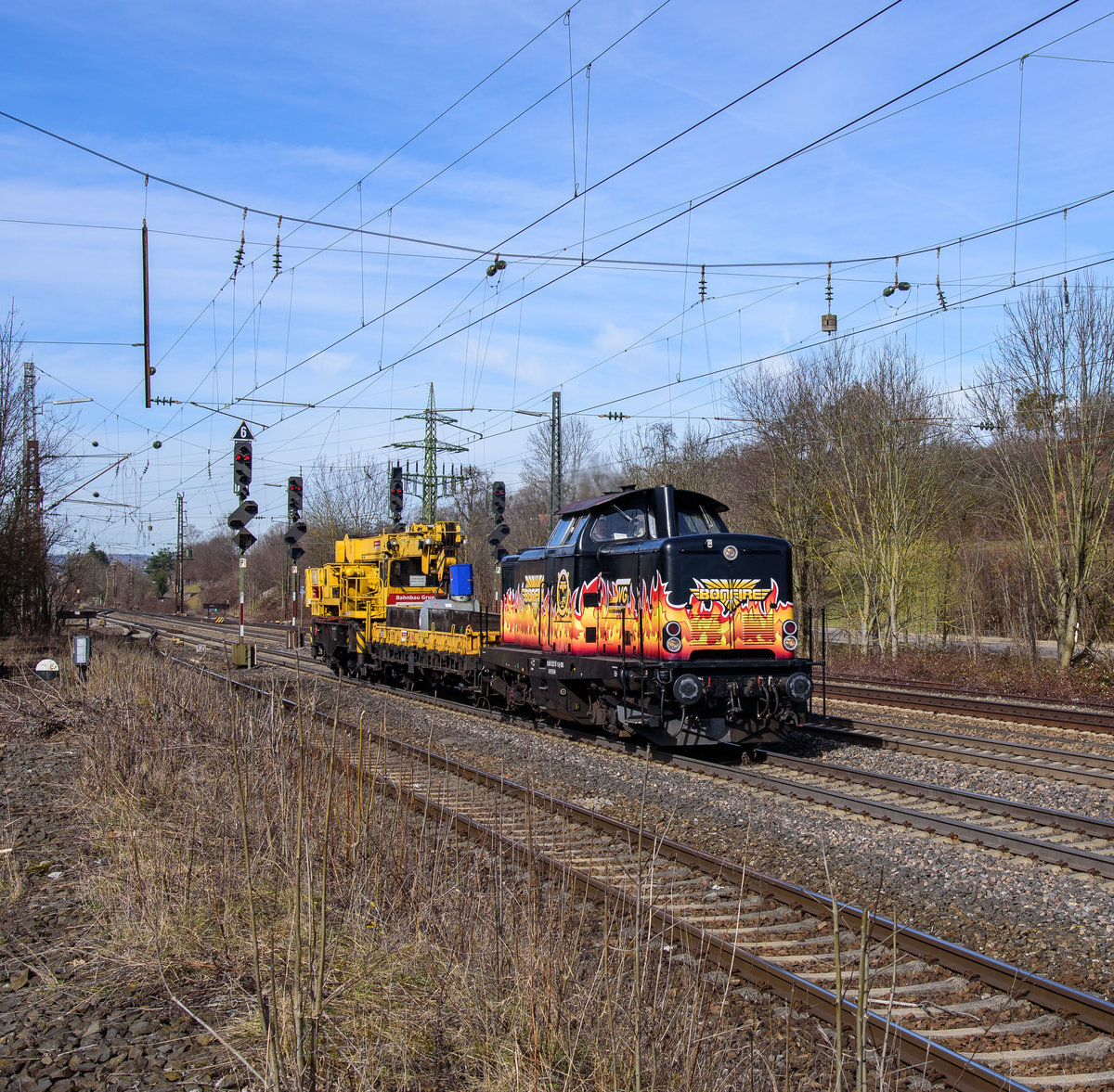212 311 der Stauden Verkehrs Gesellschaft mbH (SVG) im Look der Heavymetal Band Bonfire durchfährt mit einem Schienenkran am Haken den Bahnhof Süßen in Richtung Ulm.(4.3.2017)