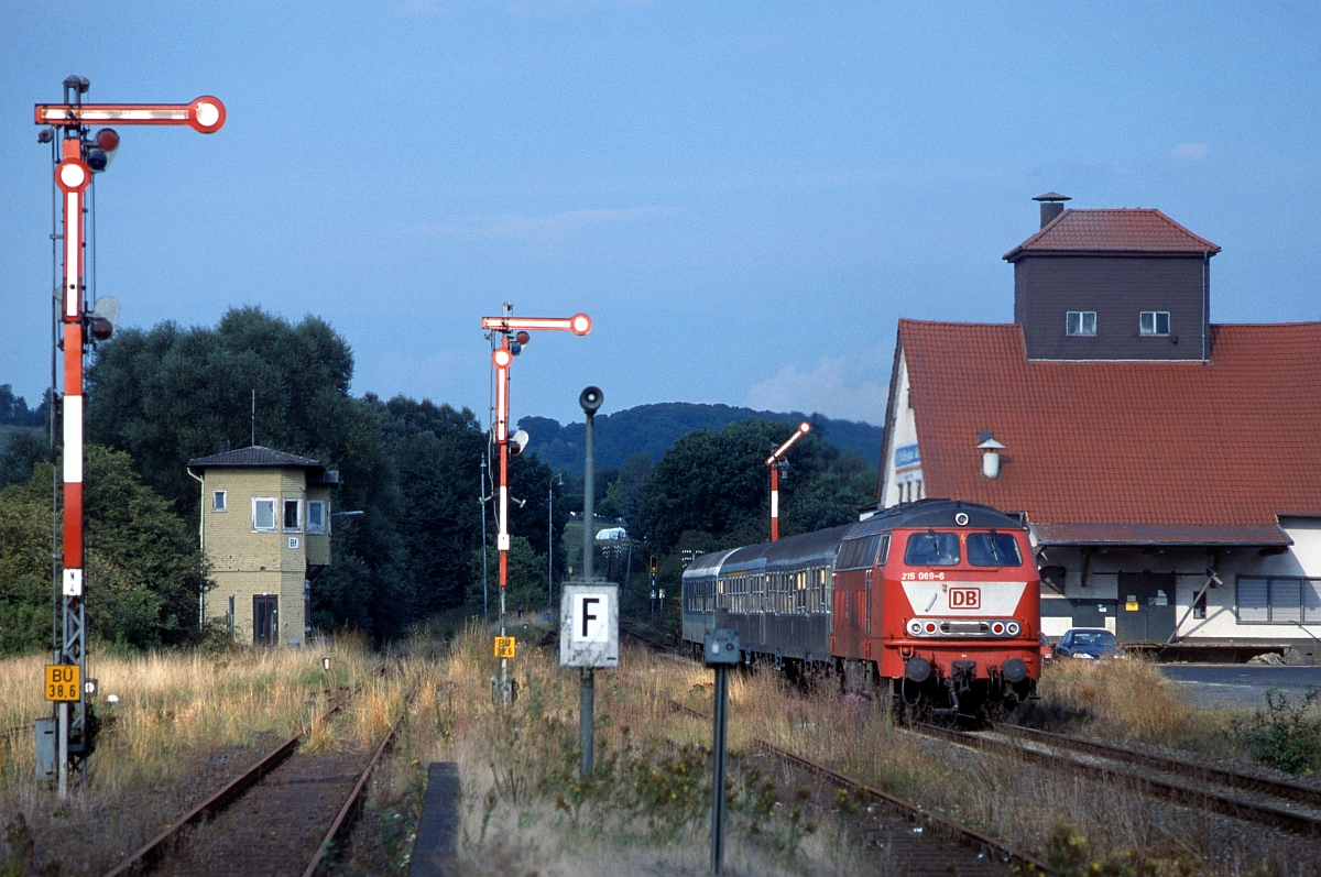 215 069 schiebt am 7.9.1999 ihren Wendezug nach Fulda aus dem Bahnhof Burg- und Nieder Gemünden, der damals schon bessere Zeiten gesehen hat (vom heutigen Zustand ganz zu schweigen !).