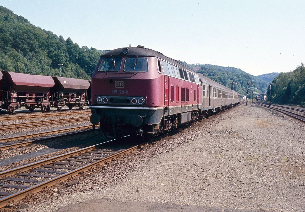 215 129 mit Eilzug aus Kall bei der Einfahrt in Brügge, August 1983