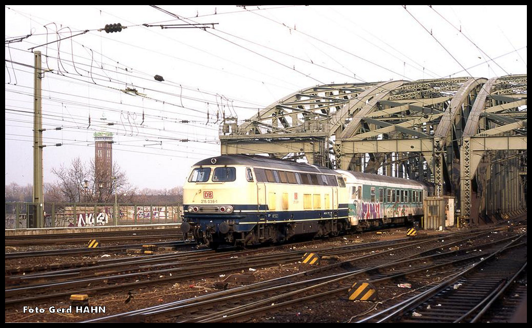 215035 verlässt mit einer RB nach Jünkerath am  20.03.1996 um 16.05 Uhr aus Köln Deutz kommend die Hohenzollernbrücke und fährt in den HBF Köln ein.