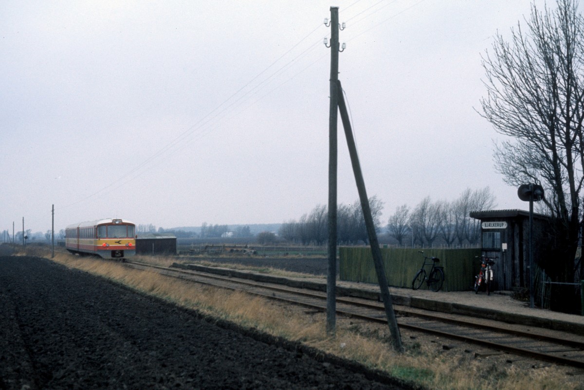 Østbanen am 23. Dezember 1975: Haltepunkt Bjælkerup mit Wartehäuschen und Haltesignal. - Ein Triebzug (Ym + Ys) ist eben am Haltepunkt vorbeigefahren. 