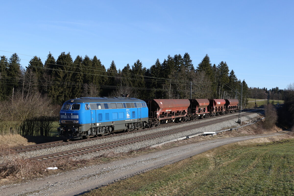 218 054 mit vier Schotterwagen aus Freilassing kommend am 10. Februar 2022 bei Grabenstätt im Chiemgau.