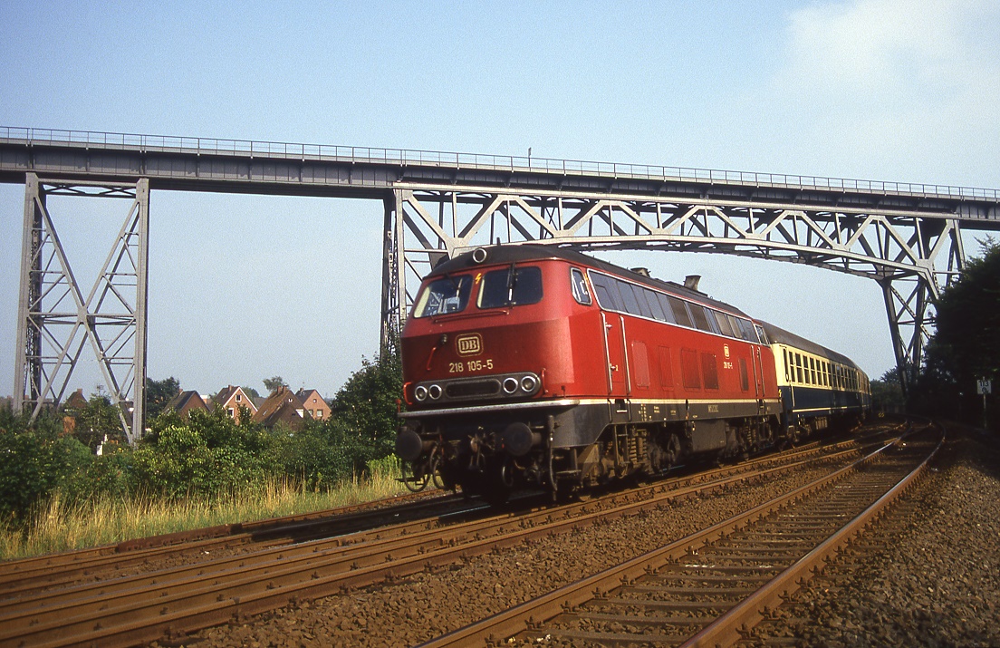 218 105 hat die Rendsburger Brücke überquert und beendet die Schleifenfahrt mit Erreichen des Bahnhofs, 03.09.1987.
