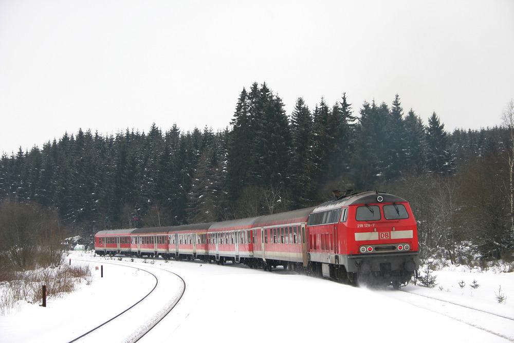 218 128 verlässt mit einem Regionalzug den Bahnhof Blankenheim (Wald) gen Süden.
Das Foto entstand am 5. März 2005.