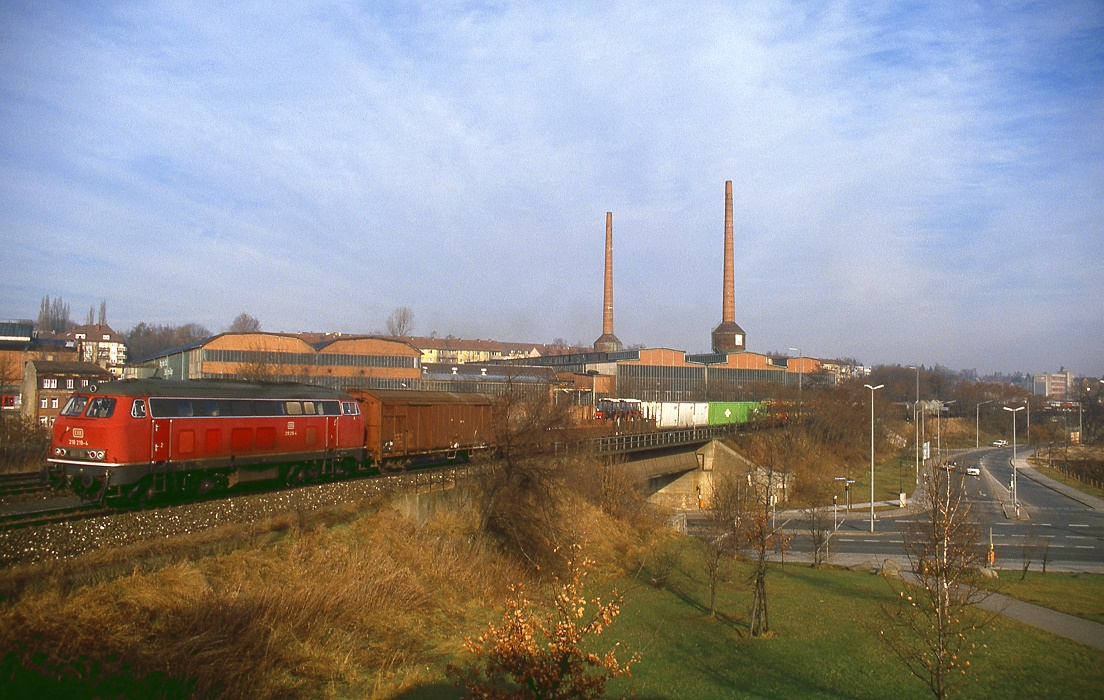 218 219 fährt durch Nürnberg Ost, im Hintergrund das Gelände zur 150-Jahr Feier der deutschen Bahnen, 23.12.1985.