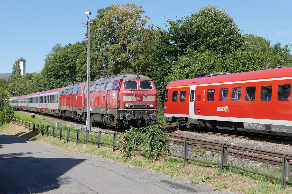 218 326-7 und eine unerkannt gebliebene 218er mit den Wagen des IC 119, Mnster(Westf) - Innsbruck, begegnen am 11.08.2018 beim Abzweig Lindau-Aeschach dem RE 3992 von Lindau ber Memmingen nach Ulm.