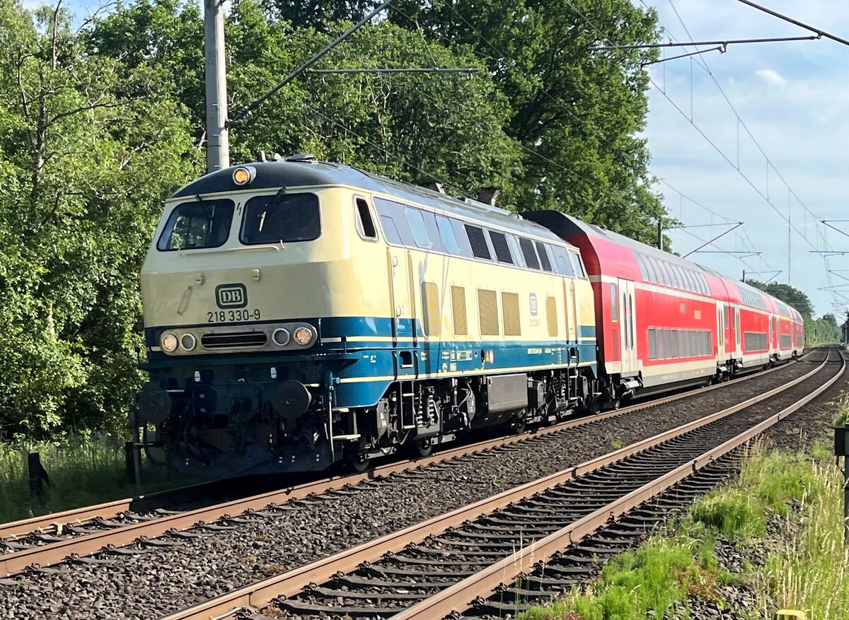 218 330-9 von NAH.SH ist nach langer Revitalierungsphase inkl. Neulack heute am 21.06.2022 erstmalig wieder im Einsatz auf ihrer Stammstrecke mit dem  Sprinter  RE8X auf dem Weg von Hamburg Hbf über Lübeck Hbf nach Kiel Hbf. Hier ist sie zu sehen bei der Durchfahrt in Ahrensburg, BÜ Grävingshorst