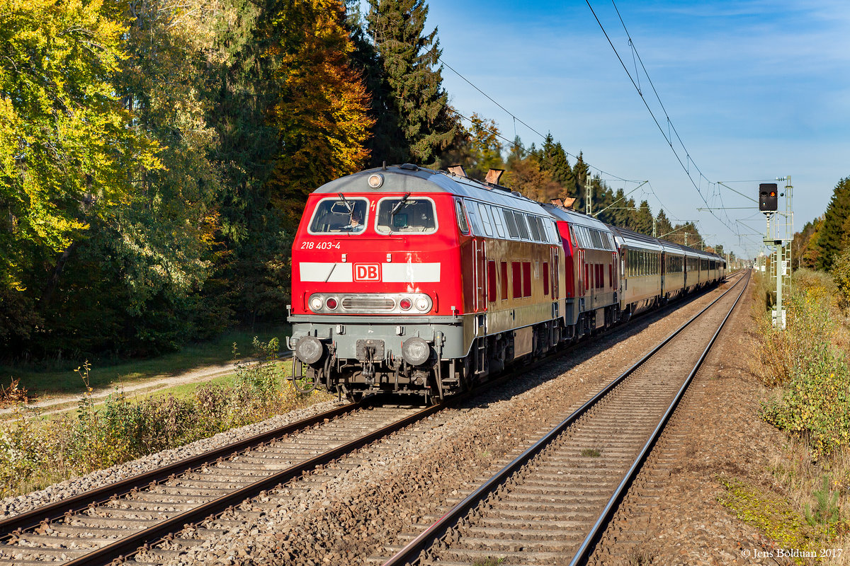 218 403 glänzt in der Herbstsonne, als sie am 13.10.2017 mit einer Schwesterlok den EC 192 von München nach Lindau durch den Schöngeisinger Forst westlich von Fürstenfeldbruck zieht. Aufgenommen am S-Bahn-Haltepunkt Schöngeising