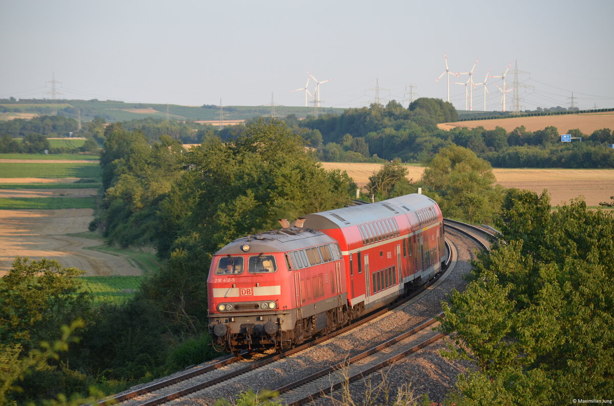 218 412 zieht am Abend des 2. August 2014 in den letzten Sonnenstrahlen ihren kurzen Regionalexpress von Alzey nach Mainz durch Armsheim. 