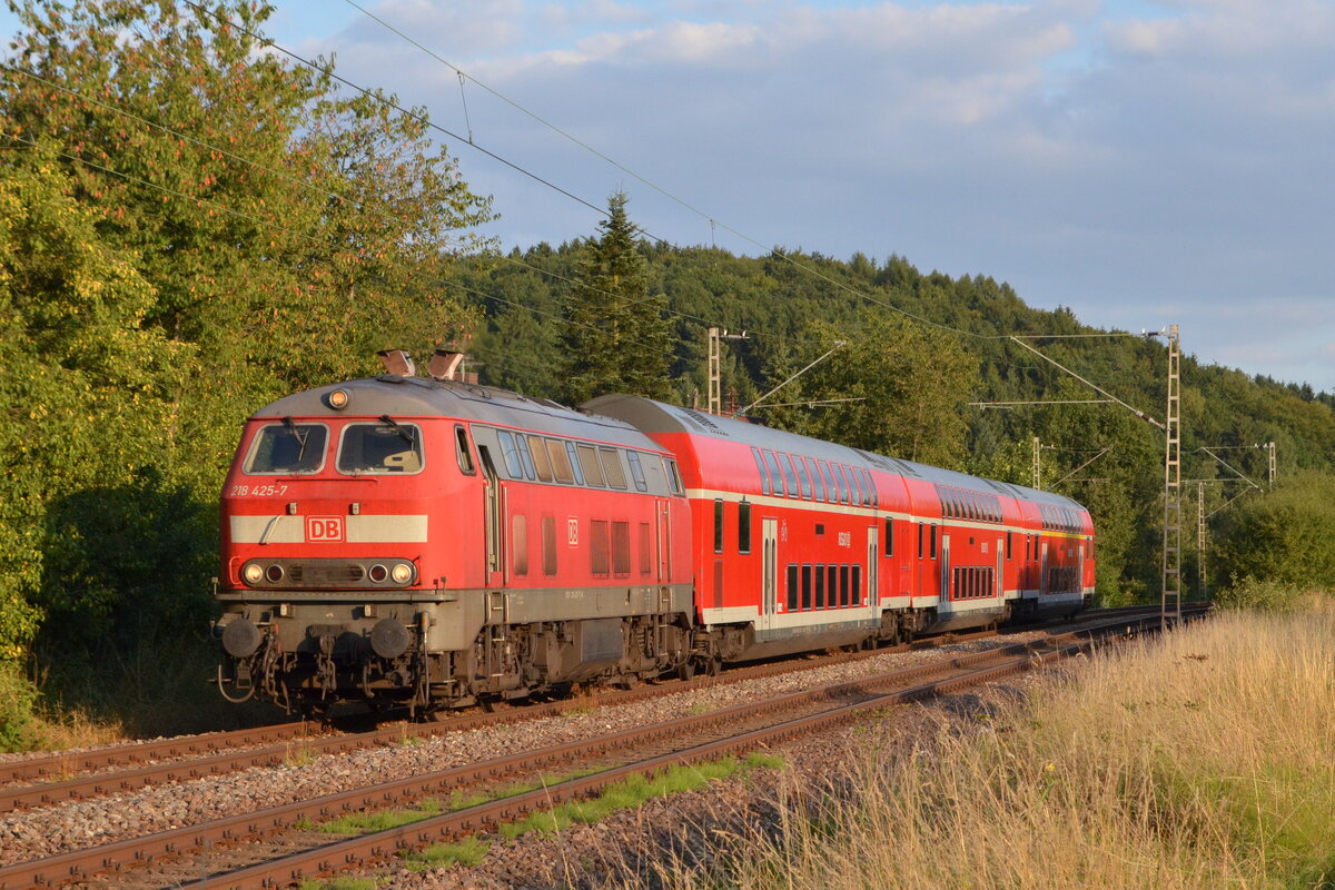 218 425 zieht am  Abend des 12. August 2013 ihren aus drei Doppelstockwagen gebildeten RE 3 (Saarbrücken-Mainz) durch Wahlhausen (Saar) und erreicht in einigen Augenblicken Türkismühle. Sehr selten wurde diese Garnitur als Ersatz für Dieseltriebwagen der Baureihe 612 eingesetzt, die bis zur Übernahme durch die vlexx den RE 3 und das Nahetal prägten. 