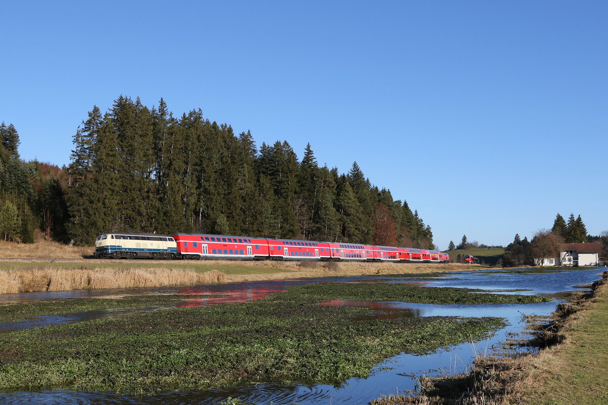 218 446 aus München kommend am 21. November 2021 bei Ruderatshofen im Allgäu mit der aufgestauten  Kirnach  im Vordergrund.