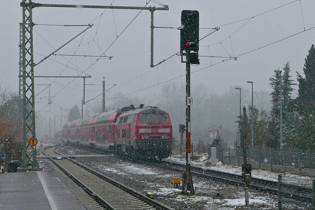 218 463-8 schiebt am 10.02.2021 die Wagen des RE 5 / RE 4213, Stuttgart - Lindau-Insel, durch den Bahnhof von Eriskirch.