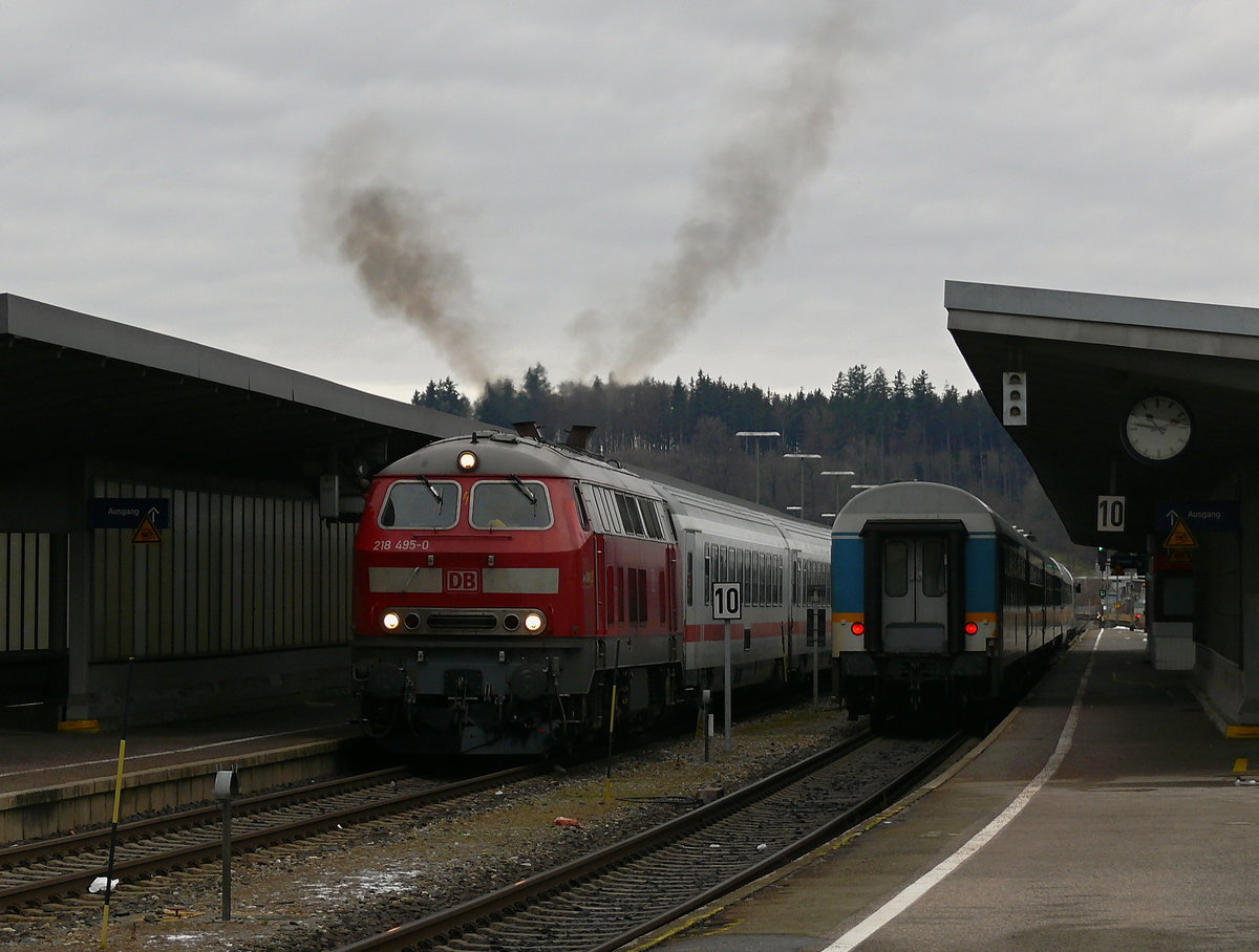 218 495 fährt am 5.12.20 mit IC 2084 (Oberstorf-Hamburg) mit einer großen Rußwolke aus dem Bahnhof Kempten (Allgäu) aus. Neben ihr steht gerade ein ALEX Zug und wartet auf die Abfahrt in Richtung Lindau.