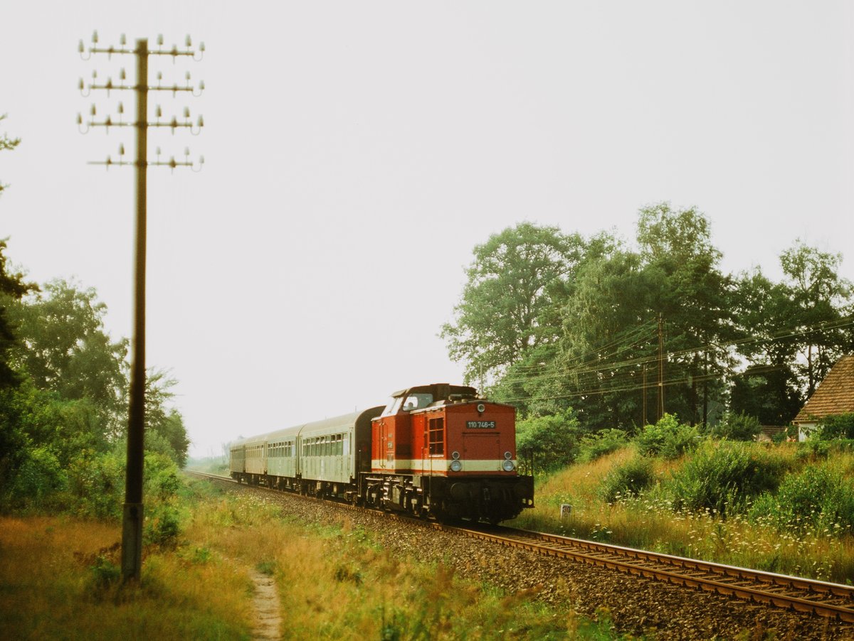 21.August 1985, An der Strecke Wismar - Rostock bei Neubukow fotografierte ich diesen Personenzug. Lokgeschichte: 1974   Auslieferung an DR als 110 746. 1986 Umbau in 112 746 im Bw Cottbus. 2001 Ausmusterung. Vermietung an zahllose EVU's. 2007 an PRESS als 202 746.