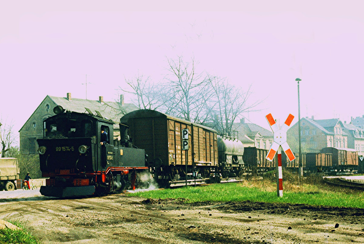 22. Oktober 1985 in Oschatz. Kurz vor der Einfahrt in den Bahnhof erwartet Lok 99 574 Schiebehilfe für die leichte Steigung