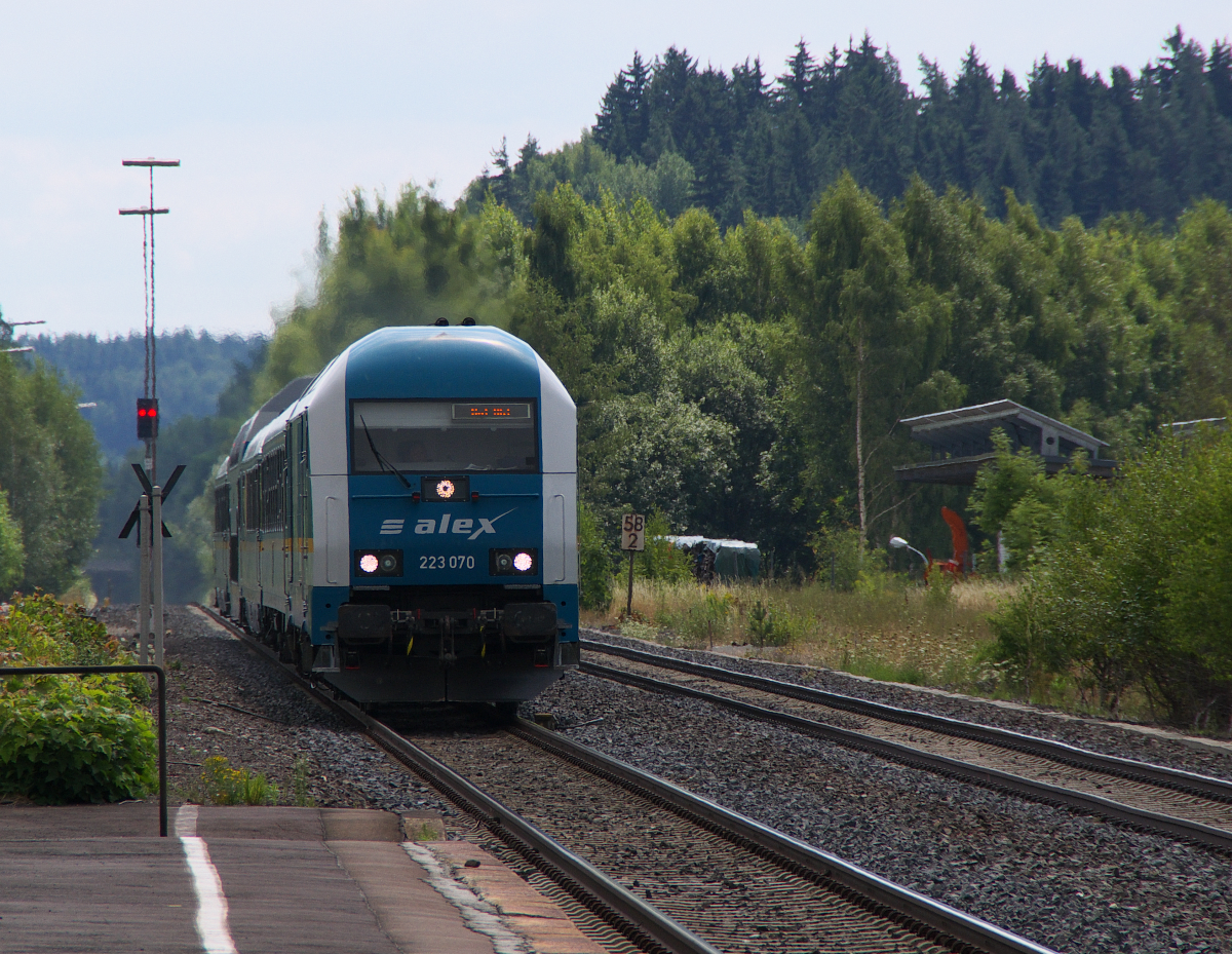 223 070 braust mit dem ALEX München - Hof am 15.08.2013 durch den ehemaligen Bahnknoten Wunsiedel-Holenbrunn. Neben der Strecke 5050 Weiden - Oberkotzau gab es in Holenbrunn noch die Verbindungen (5032) Holenbrunn - Selb und (5031) Holenbrunn - Leupoldsdorf.  